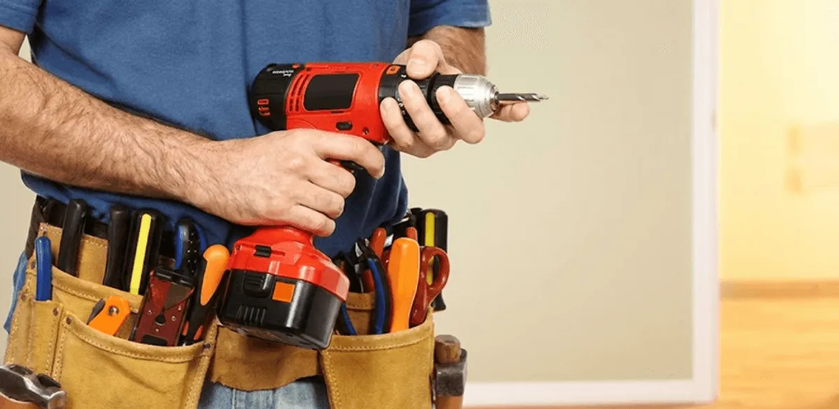 Handyman holding a power drill for home repairs and installations in Denver, CO